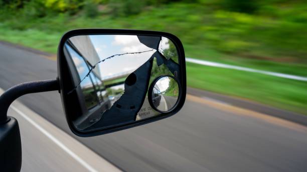 It's behind you! This shot is of a side view mirror on a van traveling down the highway in Bristol, Connecticut. The mirror is cracked and broken, The grass, trees, plants, and road blur nicely. broken side view mirror stock pictures, royalty-free photos & images