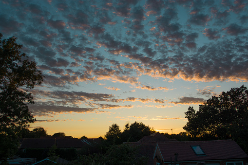 Beautiful mottled texture sunset clouds over a rural village in Sussex, United Kingdom.