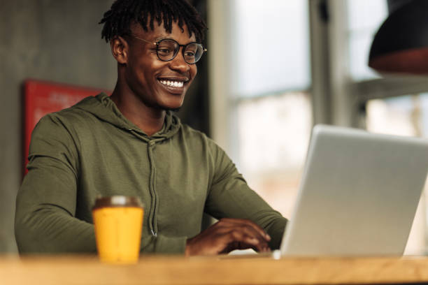 istock handsome African American man is typing on a laptop while sitting in a cafe. young student on distance learning at home 1347366745