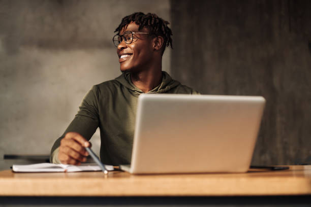 istock African American man with laptop and notepad at the table. a man writes with a pen in a notebook. distance learning 1347367409