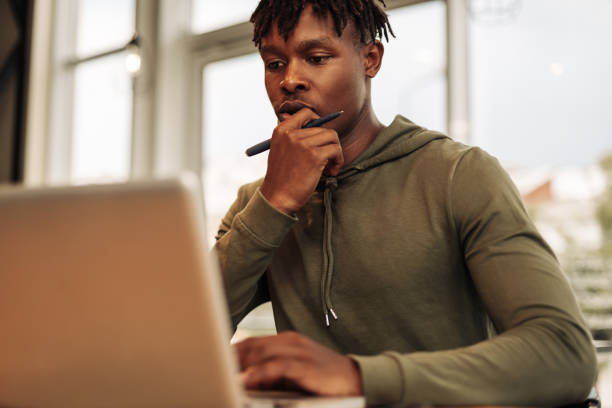 istock African American man with laptop and notepad at the table. a pensive, focused, serious man 1347367796
