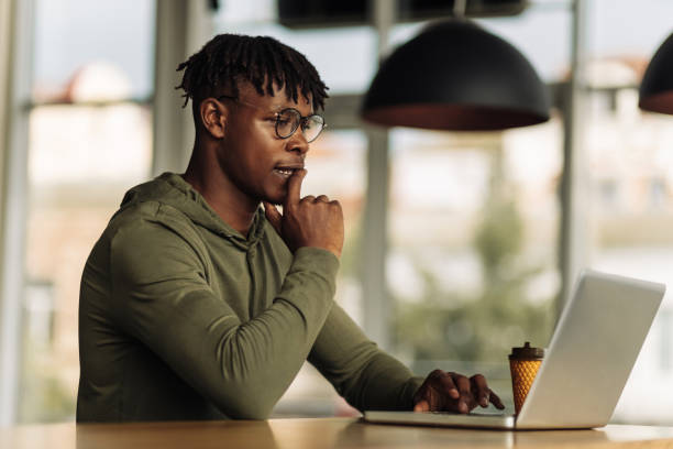 istock handsome African American man is typing on a laptop while sitting in a cafe. young student on distance learning at home 1347368674