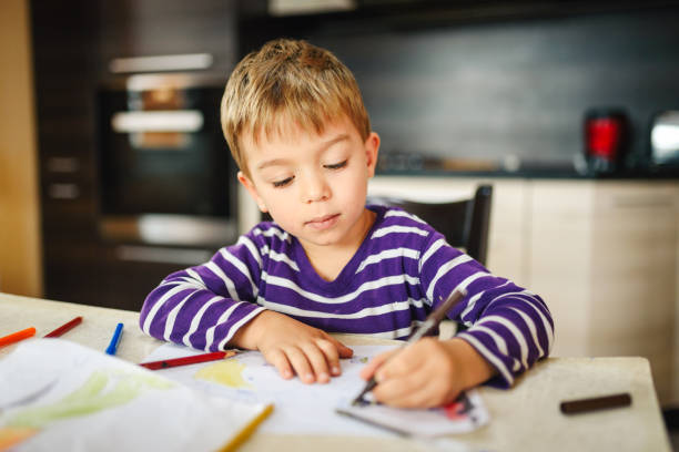 istock Cute boy drawing at home 1347369476