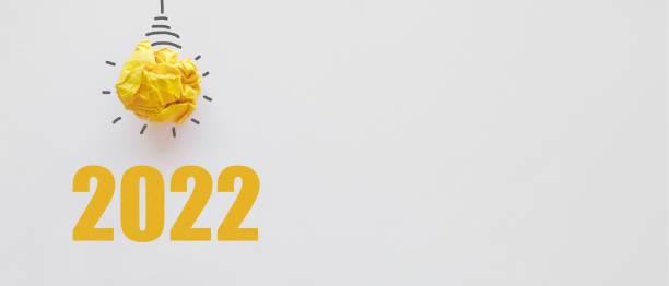 istock 2022 with Yellow paper light bulb, innovative business vision and resolution concept 1347375406