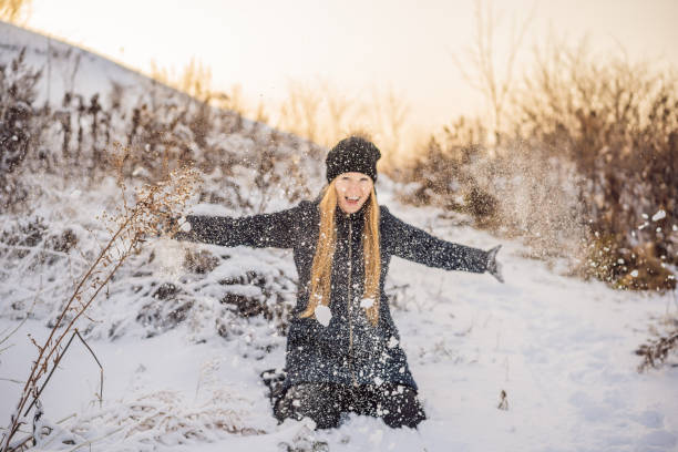 istock Woman has fun in winter, throws snow 1347378246