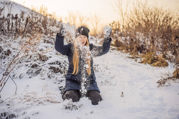istock Woman has fun in winter, throws snow 1347378248