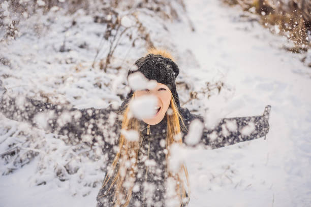 istock Woman has fun in winter, throws snow 1347378251