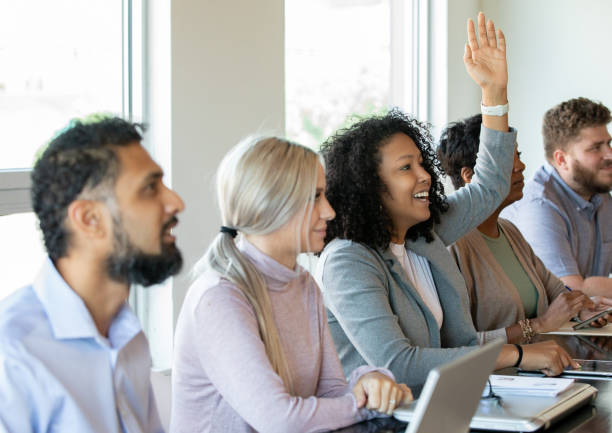 istock Young woman raises hand during professional training class or workshop 1347384481