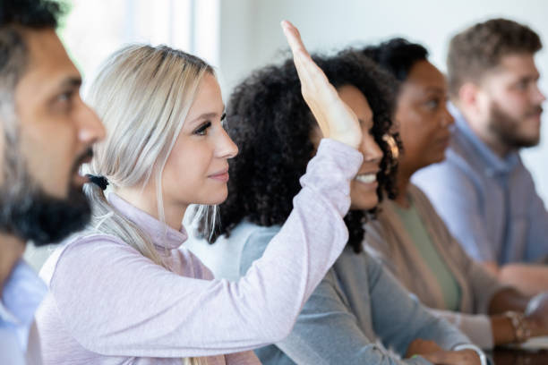 istock Professional young woman raises hand during training workshop or seminar 1347384485