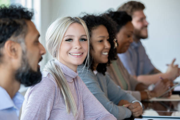 istock Woman smiles while attending job training seminar or workshop 1347384489