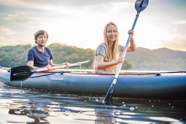 Man and woman swims on kayak in the sea on background of island. Kayaking concept.Kayaking concept with family of father mother at sea Man and woman swims on kayak in the sea on background of island. Kayaking concept.Kayaking concept with family of father mother at sea. couple punting stock pictures, royalty-free photos & images