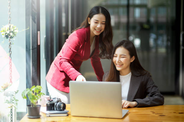istock Two female colleagues using laptop computer together, discussing online project 1347395900