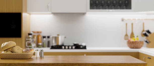 istock Luxury wooden kitchen tabletop with bread basket, empty space for montage on blurred modern kitchen background. 1347395941