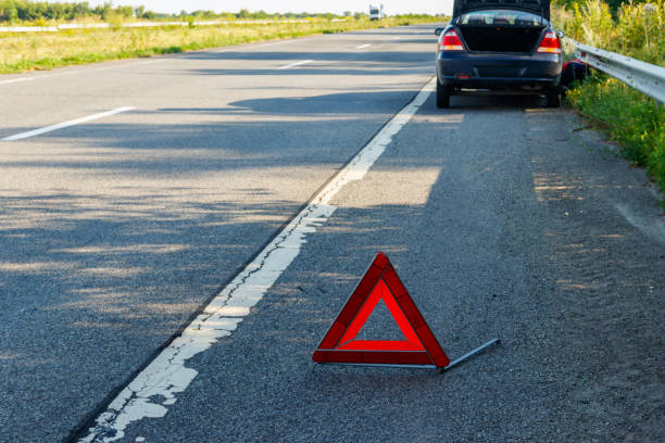 istock Red emergency stop sign (red triangle warning sign) and broken car on road 1347396196