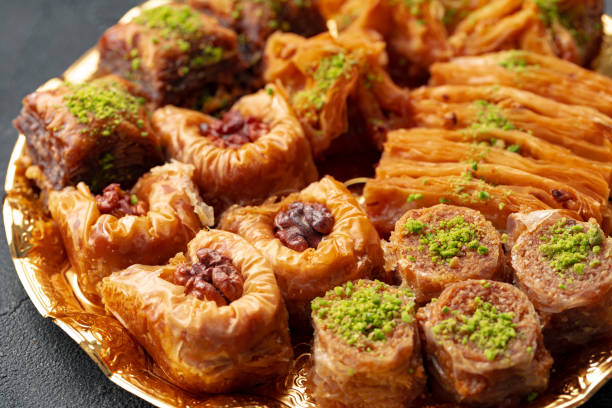 istock Delicious baklava dessert in oriental setting on black background 1347398219