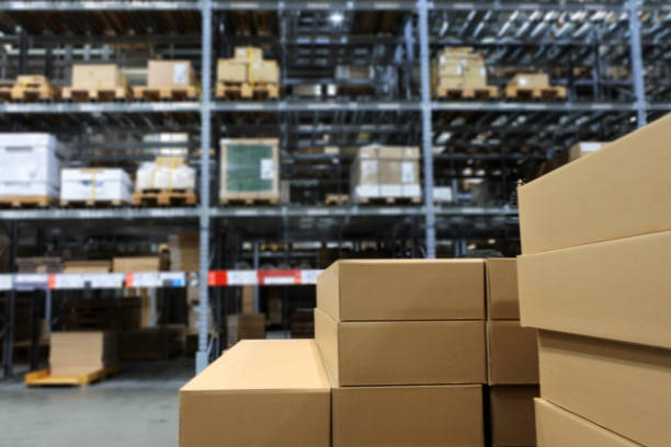 Many items inside cardboard boxes on warehouse storage shelves stock photo