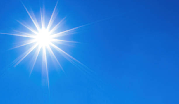 istock Shining sun over perfect blue sky background 1347398815