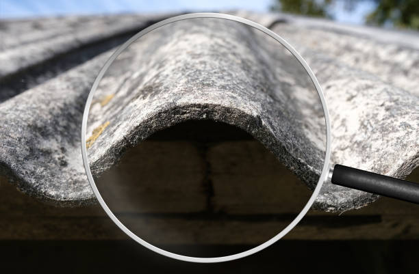 Old and very dangerous asbestos roof. Asbestos dust in the environment. Health problems. View through magnifying glass stock photo