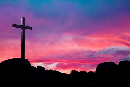 Silhouette of Christian cross at sunrise or sunset concept of religion