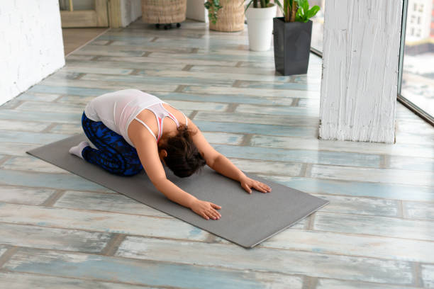 istock Middle aged woman stretching back in home interior 1347403738