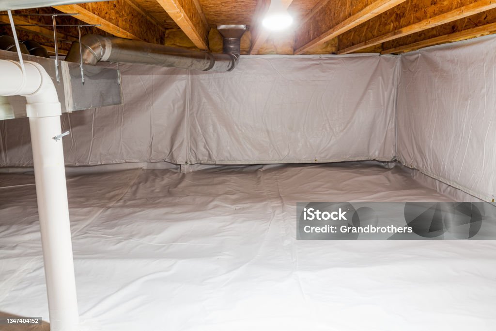 encapsulated crawl space at a basement Crawl space fully encapsulated with thermoregulatory blankets and dimple board. Radon mitigation system pipes visible. Basement location for energy saving home improvement Crawl Space Stock Photo