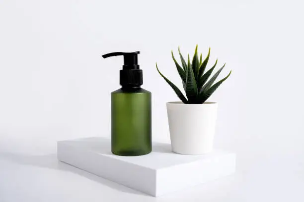 Set of cosmetic products on a light background green plastic pump bottle for lotion.