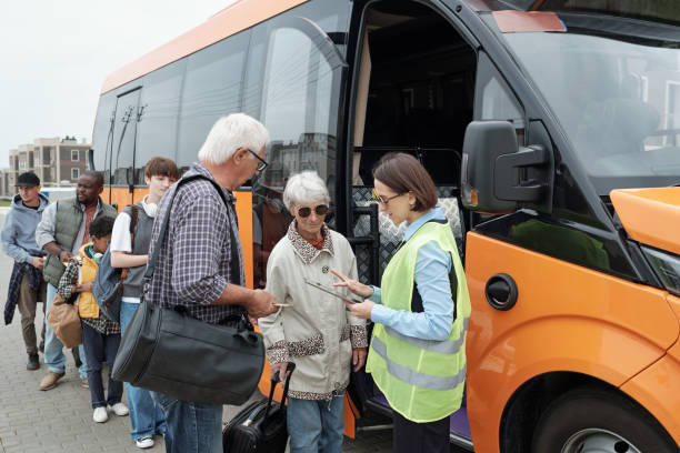 istock Bus conductor checking tickets of passengers before ride 1347405613