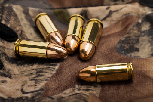 9 mm gun ammunition bullets on  camouflage background