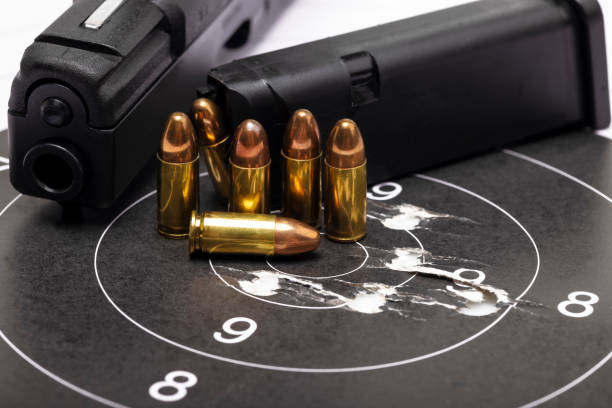 istock Gun bullets on bull eye paper target and semi automatic handgun background 1347406182