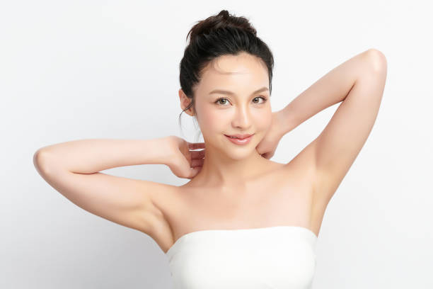 美しい若いアジアの女性は、白い背景に清潔で衛生的な脇の下や脇の下を披露するために手を上げ、滑らかな脇の下の清潔さと保護コンセプト - 腋の下 ストックフォトと画像