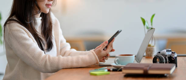 istock Side view, close-up, Female freelancer uses modern smartphone 1347407957