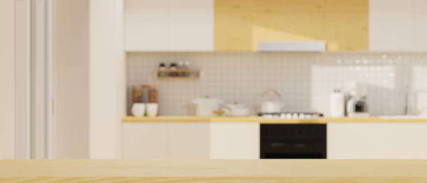 istock Wooden table top with mockup space over modern spacious bright kitchen space in background. 1347409302