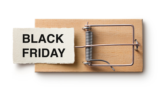 Paper note with Black Friday written on it on a mousetrap isolated on white background.