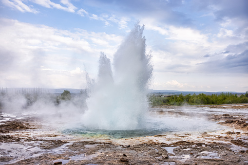 Iceland Erupting Strokkur Geyser under summer cloudscape. Strokkur Geyser is a fountain-type Geyser located in a geothermal area beside the Hvítá River in southwest part of Iceland, east of Reykjavík. Strokkur Geyser, Haukadalur, Iceland, Nordic Countries, Northern Europe.