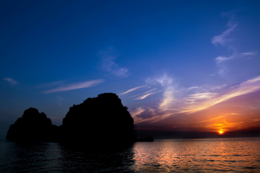 Silhouetted rocks against a beautiful sunset in Thailand  a.m.