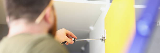 istock Man twists fitting in the cabinet with screwdriver 1347414305