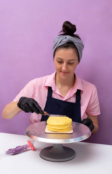 istock Leveling the yellow cream on the bento cake with a scraper. The assembly process. Selective focus. 1347415778