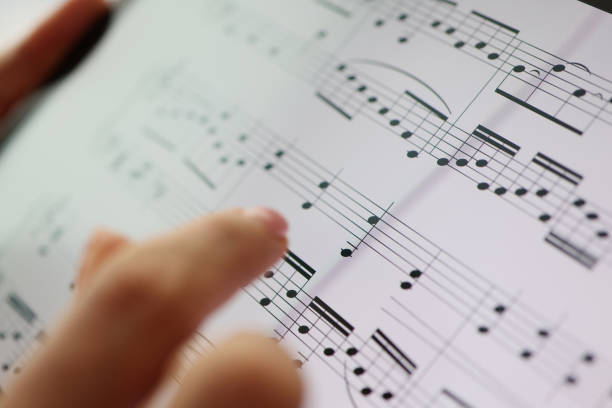 istock Woman finger points to musical notes. Classical music and music education 1347416558