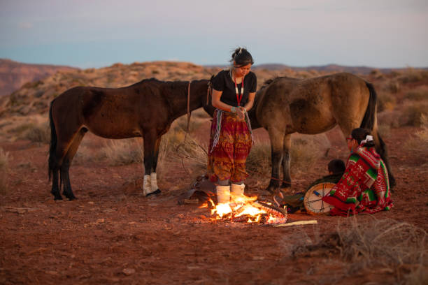 istock Navajo siblings warming up around campfire at dusk 1347417806