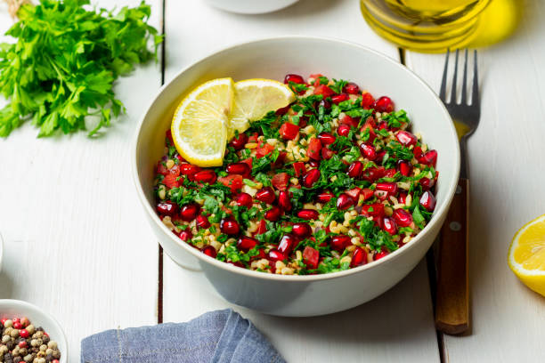 Tabbouleh salad with bulgur, mint, parsley, tomatoes and pomegranate. Healthy eating. Vegetarian food. Tabbouleh salad with bulgur, mint, parsley, tomatoes and pomegranate. Healthy eating. Vegetarian food bulgur wheat stock pictures, royalty-free photos & images