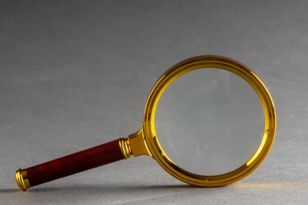istock a golden magnifier on black paper background 1347423391