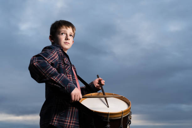 Dramatic portrait of a musician playing a classic snare drum.