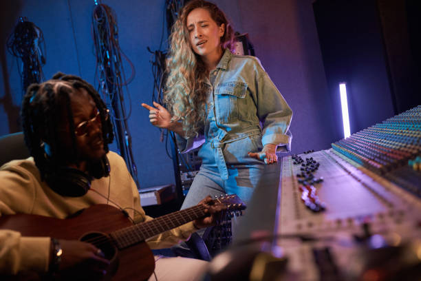 istock Young singer singing a song in the studio 1347426360