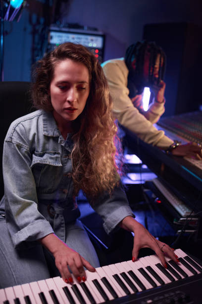 istock Woman playing synthesizer in the recording studio 1347426522