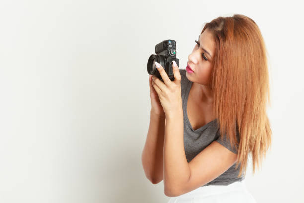 istock Brunette woman taking pictures with digital camera 1347429143