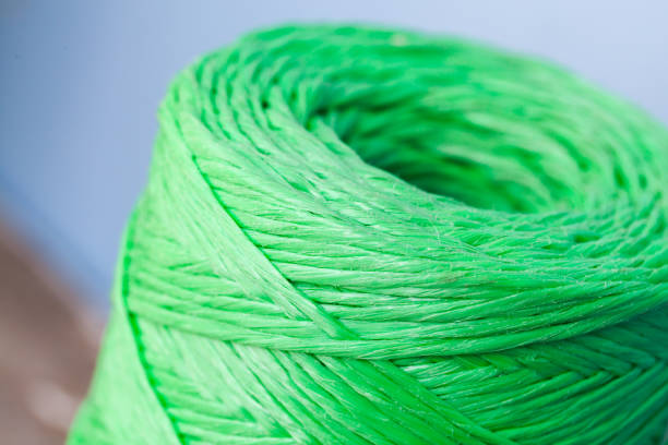 Skein of green polypropylene cord over blurred background, closeup photo with selective focus