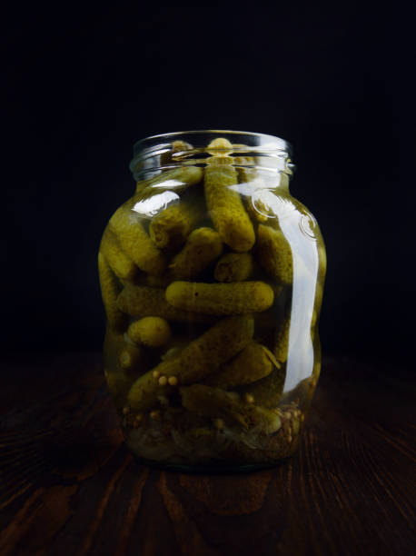 istock An open jar with juicy pickled cucumbers stands on a wooden surface. 1347435498