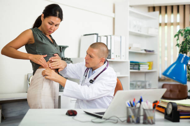 Doctor palpating abdomen of female patient in medical office Qualified doctor palpating abdomen of Asian female patient suffering from pain in medical office anamnesis stock pictures, royalty-free photos & images