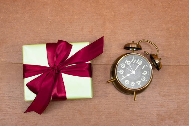 istock Gift box with alarm clock over wood table 1347441426