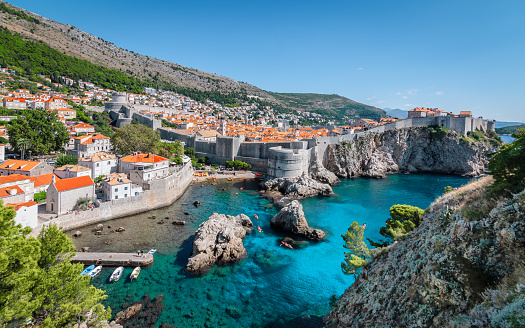 Beautiful high angle view of the old town with surrounding walls in Dubrovnik, Croatia. View from the top of the mountain. Panoramic view. Blue sky. Bright colors.